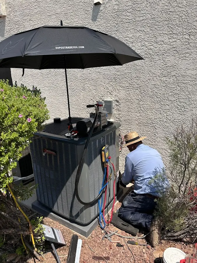 HVAC technician performing outdoor AC maintenance in Groveland