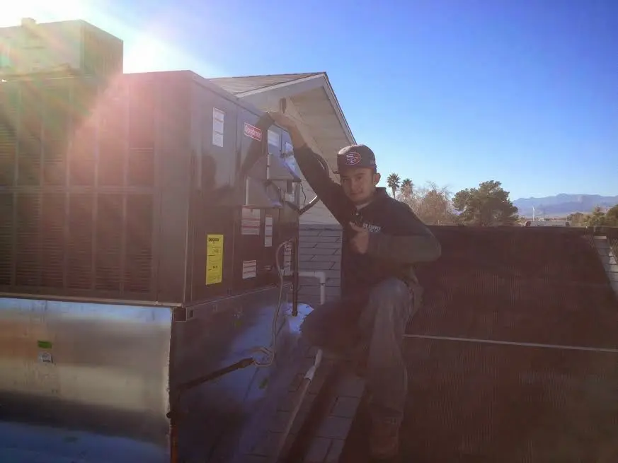 HVAC technician performing AC Tune-Up on a rooftop unit in Groveland